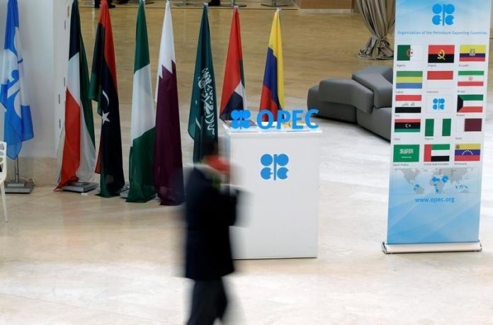 A man walks past an OPEC logo ahead of an informal meeting between members of the Organization of the Petroleum Exporting Countries (OPEC) in Algiers
