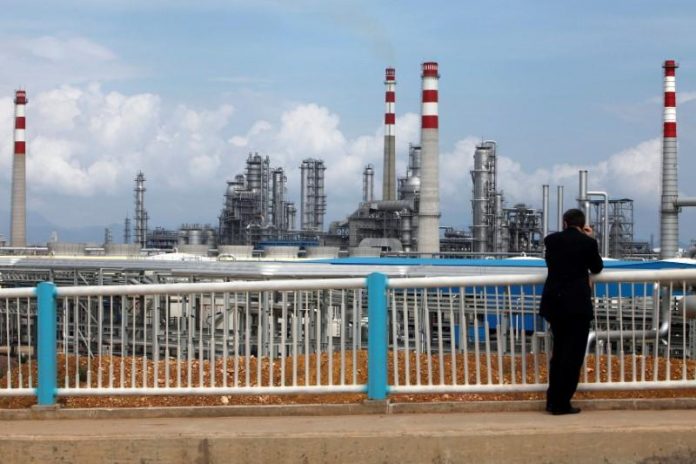FILE PHOTO: A visitor looks at CNOOC oil refinery in Huizhou