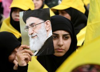 A woman carries a picture of Iran's Supreme Leader Ayatollah Ali Khamenei