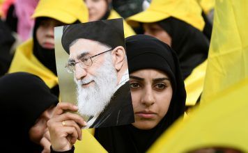 A woman carries a picture of Iran's Supreme Leader Ayatollah Ali Khamenei