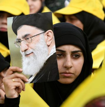 A woman carries a picture of Iran's Supreme Leader Ayatollah Ali Khamenei