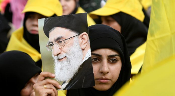 A woman carries a picture of Iran's Supreme Leader Ayatollah Ali Khamenei
