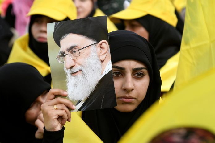 A woman carries a picture of Iran's Supreme Leader Ayatollah Ali Khamenei