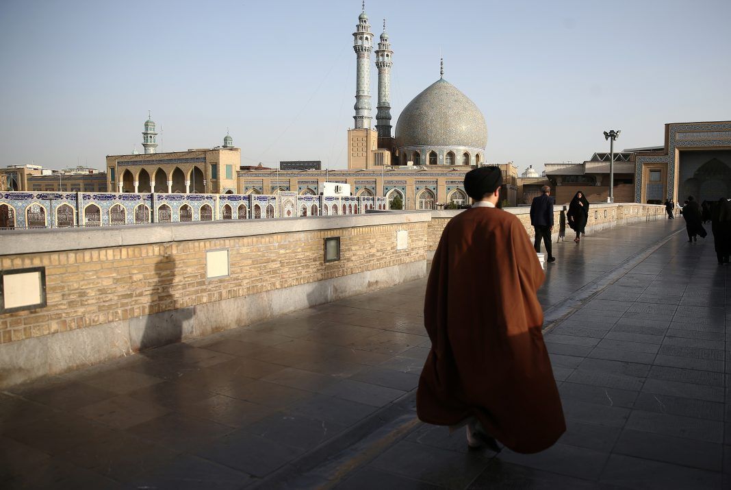 FILE PHOTO: An Iranian cleric walks in front of the Shrine of Fatima Masumeh in Qom, Iran. REUTERS./