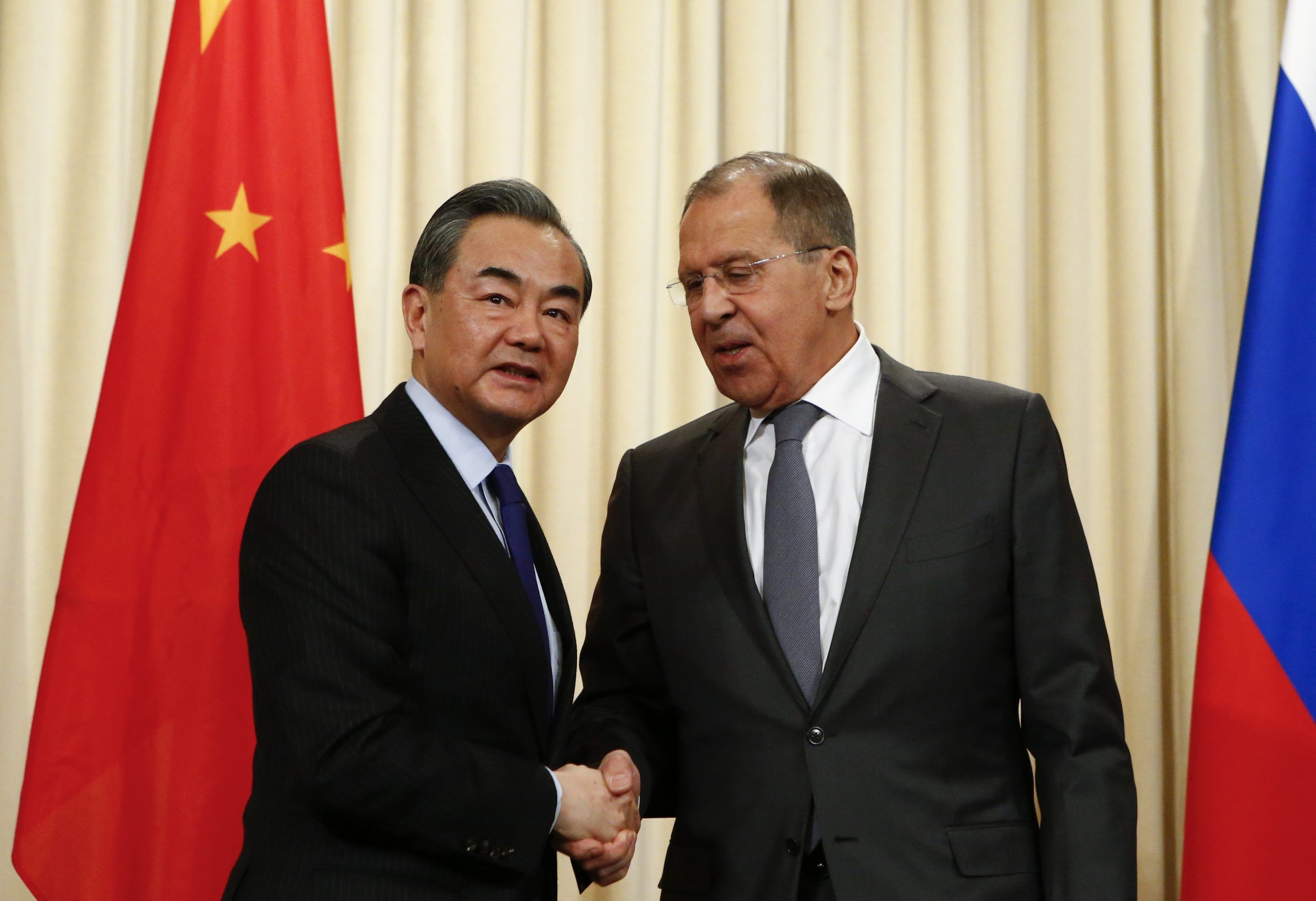 FILE PHOTO: Russia's Foreign Minister Sergei Lavrov (R) shakes hands with China’s top diplomat State Councillor Wang Yi during a news conference in Moscow. REUTERS/Sergei Karpukhin