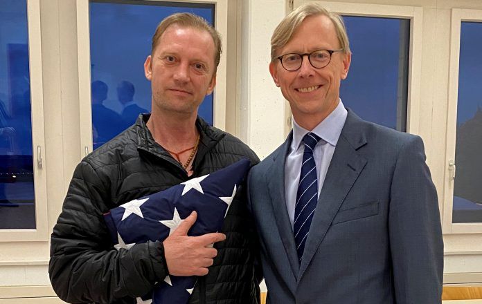 Michael White, a freed U.S. Navy veteran detained in Iran since 2018, poses with U.S. Special Envoy for Iran Brian Hook in Zurich