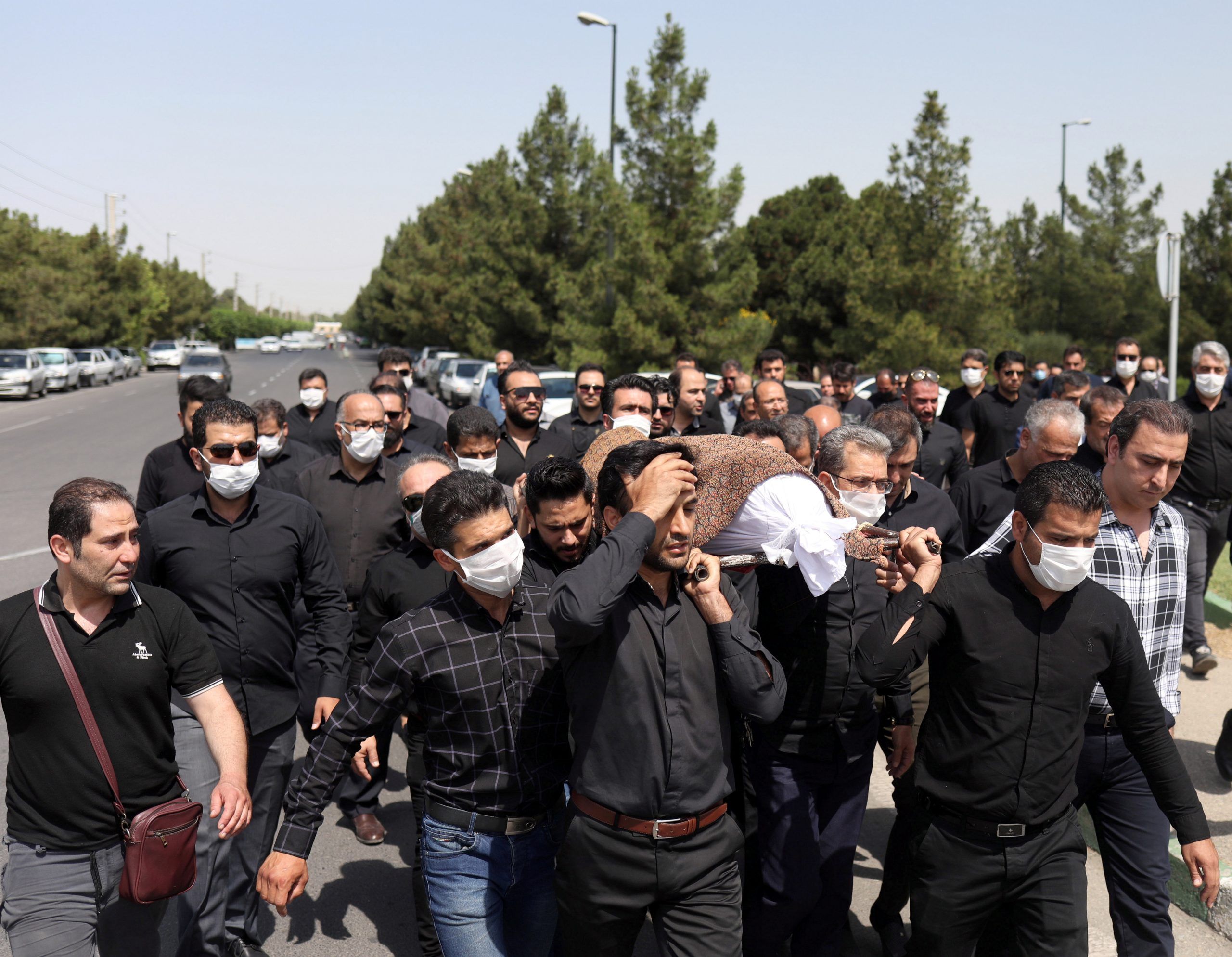 Iranians wearing protective face masks carry a coffin during a funeral ceremony, following the outbreak of the coronavirus disease (COVID-19), in Tehran, Iran June 11, 2020. REUTERS./