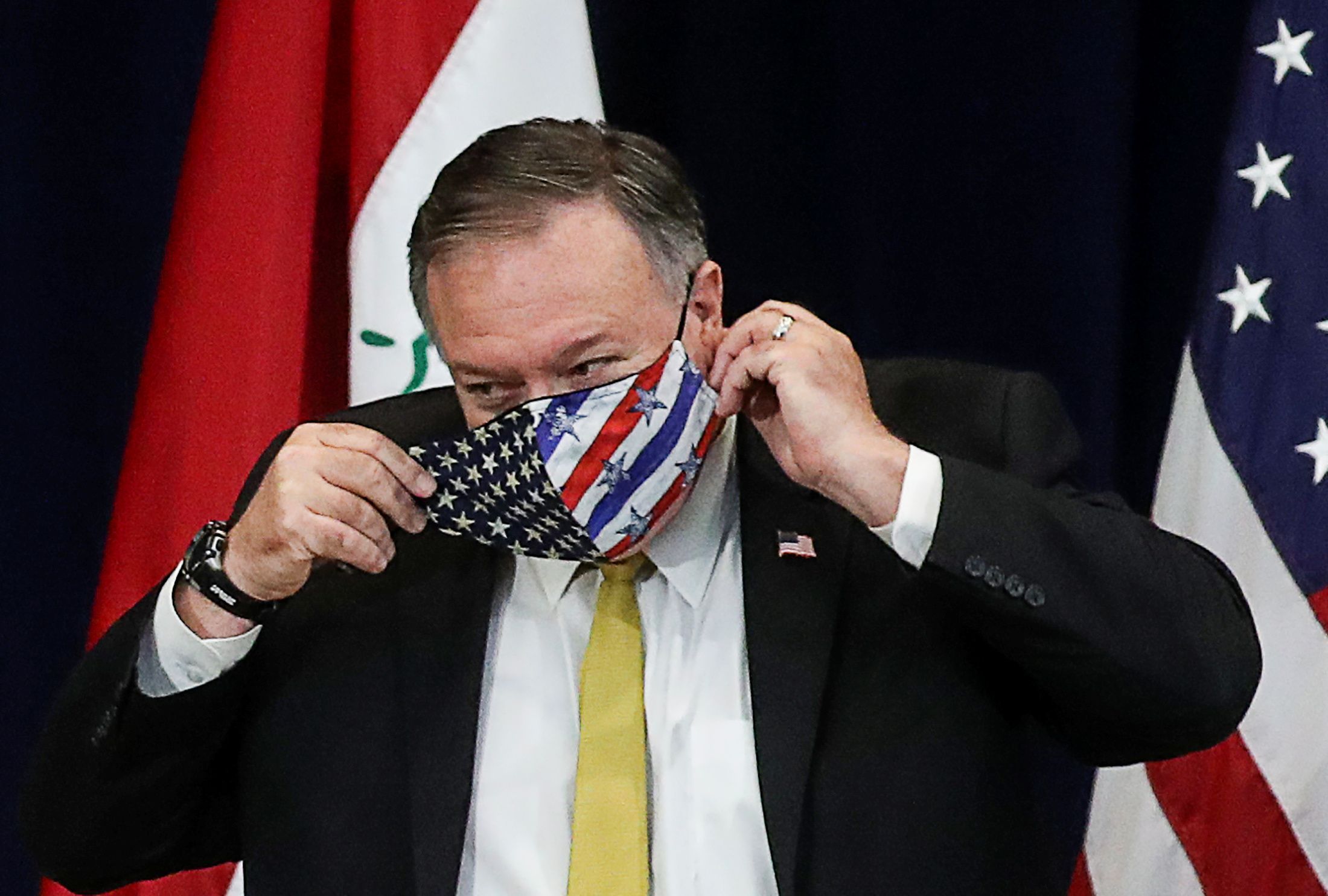 U.S. Secretary of State Mike Pompeo puts on a protective face mask as he faces reporters with Iraq?s Foreign Minister Fuad Hussein at the State Department in Washington, U.S., August 19, 2020. 