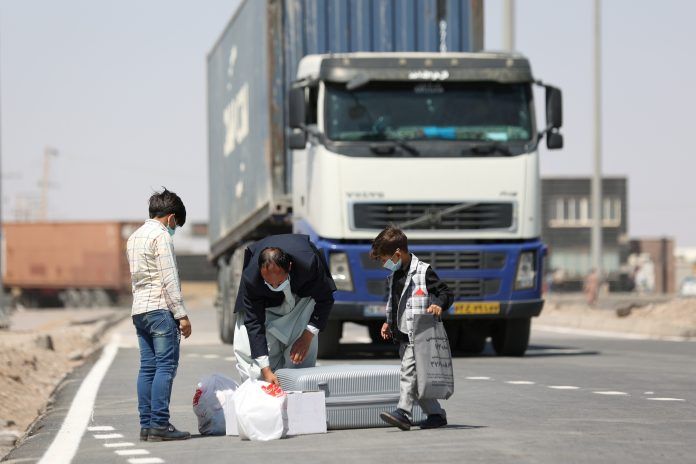 FILE PHOTO: Afghan nationals enter Iran at the Dowqarun border crossing between Iran and Afghanistan